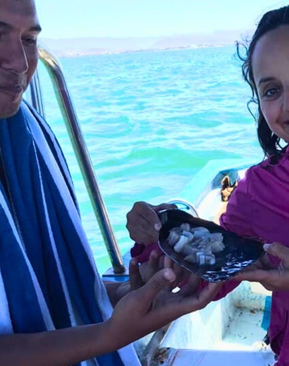 Local guide sharing fresh oysters with a traveler on a boat tour in La Paz, Baja California Surcard1_final